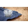 A small clear container filled with silver cleaning beads sits on a blue cloth on a wooden surface. Several beads are scattered around the cloth and on the wood. Anteprima dell’immagine prodotto