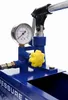 A close-up view of a blue pressure testing pump with a pressure gauge and a yellow knob. Anteprima dell’immagine prodotto