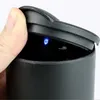 A close-up of a black container with a lid being opened by a hand, revealing a small blue light inside. Náhled obrázku produktu