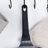 A close-up view of a frying pan handle hanging on a hook, with kitchen towels on either side. Náhľad obrázku produktu