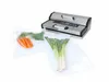 A vacuum sealer machine with vegetables in vacuum bags. Podgląd zdjęcia produktu