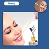 A woman's face is shown with a dropper applying liquid to her cheek, with a small bottle of liquid and flowers in the background. A small inset shows a similar scene. Produktbild-Vorschau
