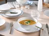 A table setting with a bowl of soup, plates, and cutlery. Náhľad obrázku produktu