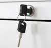 A close-up of a key in a lock on a white surface. Produktbild-Vorschau