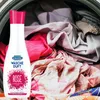 A bottle of Dr. Beckmann Wäsche Duft Rose is placed in front of a pile of laundry inside a washing machine. Podgląd zdjęcia produktu