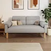 A gray sofa with decorative pillows on a wooden floor in a room with artwork and a plant. Produktbild-Vorschau