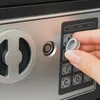 A close-up of a hand interacting with a safe's keypad. Anteprima dell’immagine prodotto