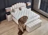 A bedroom scene featuring a bed, nightstands, and a bench. Produktbild-Vorschau