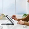 A person is using a tablet with a ZUGU case on a desk, with a window in the background. Produktbild-Vorschau