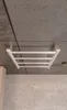 A heated towel rack mounted on a concrete ceiling. Produktbild-Vorschau