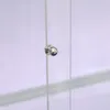 A close-up of a silver knob on a clear glass surface. Produktbild-Vorschau