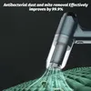A close-up of a cordless handheld vacuum cleaner with a transparent dustbin, shown in action on a green textured surface, with animated green lines and particles indicating suction and cleaning. Produktbild-Vorschau