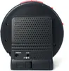 The back of a black and red electronic device, likely an alarm clock, is shown against a white background. The device has a perforated speaker grille and ports labeled 'VIBRATOR' and 'DC 9V'. Produktbild-Vorschau