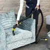 A person is using a cleaning machine to clean a patterned sofa. Produktbild-Vorschau