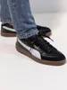 Close-up shot of a person wearing Puma sneakers. Voir les images du produit