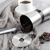 A coffee grinder with beans, a cup of coffee, and a spoon on a fabric. Produktbild-Vorschau
