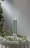 Two green LED candles in glass holders on a white surface, with ivy vines draped around them. Produktbild-Vorschau