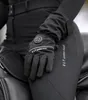 A close-up shot of a person wearing black riding pants and heated gloves. Náhled obrázku produktu
