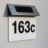 A close-up of a solar-powered house number light mounted on a textured wall. Náhľad obrázku produktu