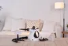 A steam cleaner and its accessories are displayed on a wooden table in front of a sofa and a floor lamp. Podgląd zdjęcia produktu