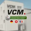 A blurred background of a building with the VCM logo and text overlays. Produktbild-Vorschau