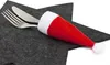 A fork and knife are placed on a dark gray star-shaped placemat, with the handles of the cutlery inserted into a small red and white Santa hat. Produktbild-Vorschau