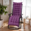 A purple cushion on a recliner chair in a room with a plant and a window. Náhled obrázku produktu