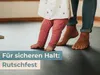 A baby and an adult's feet are shown on a dark mat, suggesting a safe play area. Anteprima dell’immagine prodotto