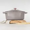 A taupe cast iron Dutch oven with a rose gold knob is displayed on a wooden board with wheat stalks and a linen cloth. Náhľad obrázku produktu