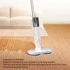 A white electric mop is shown on a wooden floor in a living room setting, with a couch and rug in the background. Produktbild-Vorschau