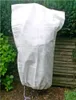 A white plant protection bag covering a plant in a garden setting. Produktbild-Vorschau