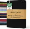A stack of folded bed sheets in various colors is shown on the left, with a black bed sheet in the foreground on the right, featuring a product label. Produktbild-Vorschau