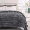 Dunkelgraue strukturierte Fleecedecke über einem Bett mit weißen Kissen im Schlafzimmer drapiert Náhľad obrázku produktu