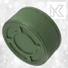 A green Christmas tree stand is shown from a low angle against a sparkling, light-colored background. Podgląd zdjęcia produktu