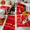 A collage of images showing a red and white patterned electric heated blanket in various settings, including on a bed, draped over a chair, and a close-up of the pattern and a mug of hot chocolate. Podgląd zdjęcia produktu