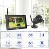 A security camera and monitor set displayed on a surface with a window in the background. Below the product, there are feature callouts with icons and text. Produktbild-Vorschau
