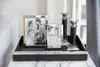 A decorative tray with two picture frames and two candlesticks on a marble surface. Produktbild-Vorschau