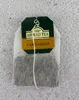 A single Ahmad Tea Cardamom tea bag is shown against a textured light gray background. Podgląd zdjęcia produktu