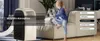 A young girl sits on a couch next to a portable air conditioner in a living room. Produktbild-Vorschau