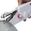 A close-up shot of a white handheld sewing machine being used to sew gray fabric. Náhled obrázku produktu