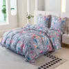A neatly made bed with floral patterned bedding in a bright room. Produktbild-Vorschau