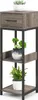 A three-tiered plant stand with a drawer, featuring plants on each shelf. Produktbild-Vorschau
