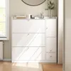 A white shoe cabinet with three flip-down drawers and a side cabinet, placed in a hallway next to a window. Produktbild-Vorschau