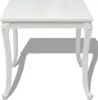 A white, high-gloss dining table with ornate legs, shown from the front against a white background. Anteprima dell’immagine prodotto