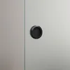 A close-up of a black circular handle on a glass sliding door. Anteprima dell’immagine prodotto