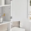 A close-up view of a white bathroom cabinet with its door open, showing hinges and a shelf with cotton balls and bottles. Voir les images du produit
