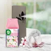 An Air Wick air freshener spray and dispenser are shown with a rolled-up towel and flowers. Anteprima dell’immagine prodotto