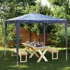 A party tent set up in a garden with a picnic table and benches. Náhled obrázku produktu