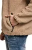 A close-up shot of a person's hand in the pocket of a tan teddy fleece jacket. Anteprima dell’immagine prodotto