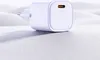 A white USB-C charger is placed on a textured white surface with soft, undulating hills in the background. Anteprima dell’immagine prodotto